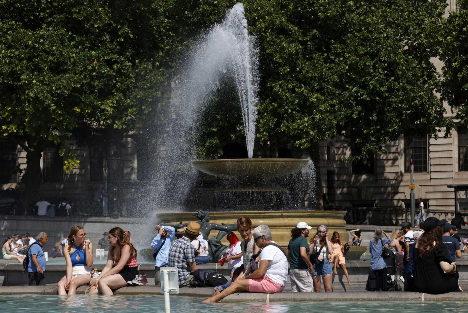 People cool off beside the fountains in Trafalgar Square in central London on June 17. Photo: AFP 