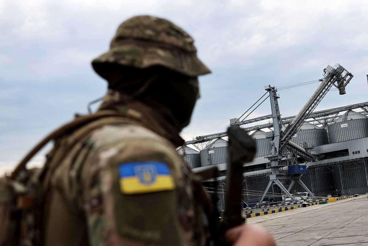 A Ukrainian serviceman stands in front of silos of grain from Odesa Black Sea port, before the shipment of grain, amid Russia's invasion of Ukraine, in Odesa, Ukraine, July 29. Photo: Reuters