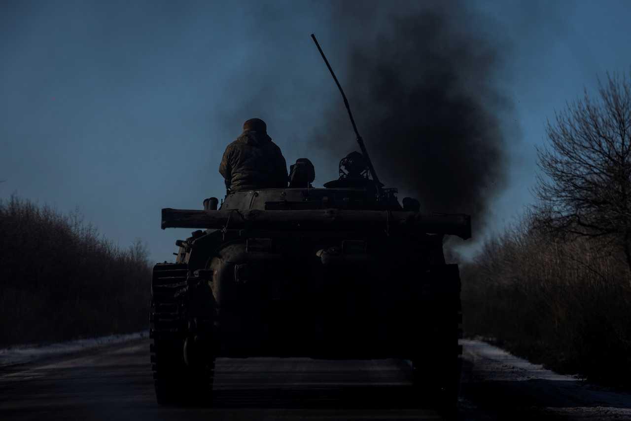 Ukrainian service members ride atop a BMP-2 infantry fighting vehicle near a frontline, amid Russia's attack on Ukraine, in Donetsk region, Feb 8. Photo: Reuters