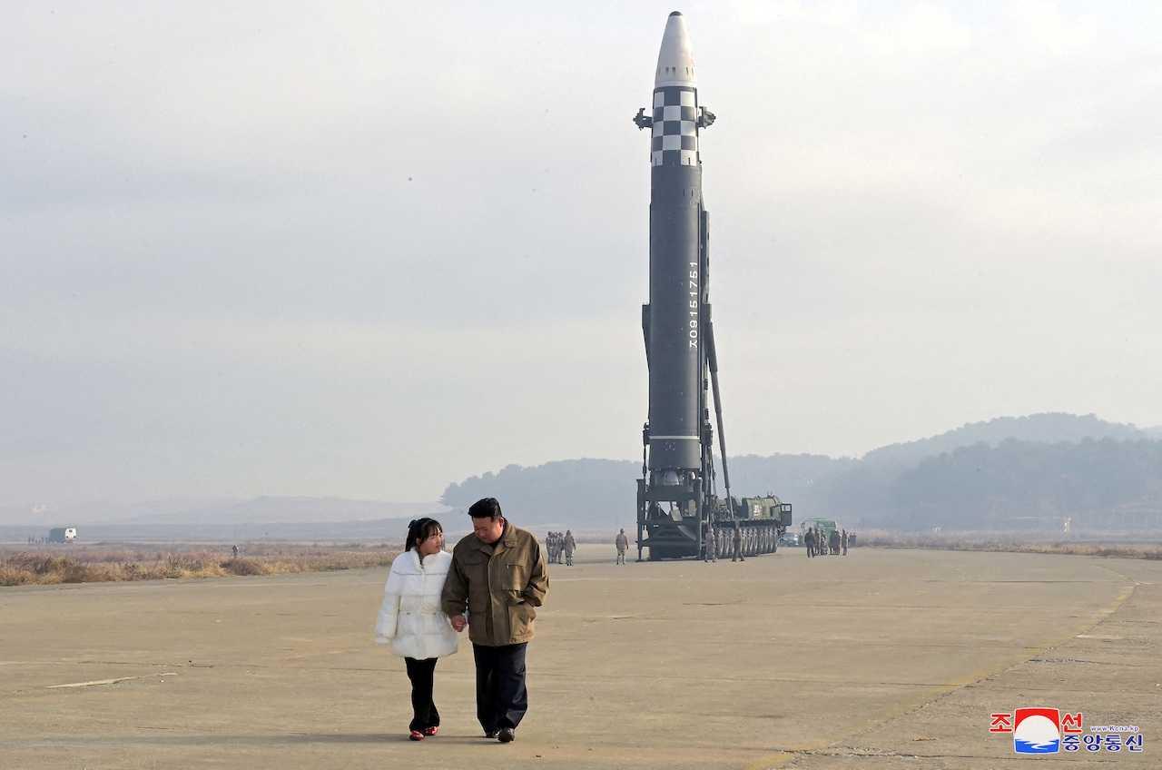 Pemimpin komunis Korea Utara Kim Jong Um bersama anak perempuannya berlatar belakangkan peluru berpandu balistik antara benua dalam gambar tidak bertarikh dikeluarkan pada 19 November 2022 oleh Agensi Berita Pusat Korea Korea Utara. Gambar: Reuters