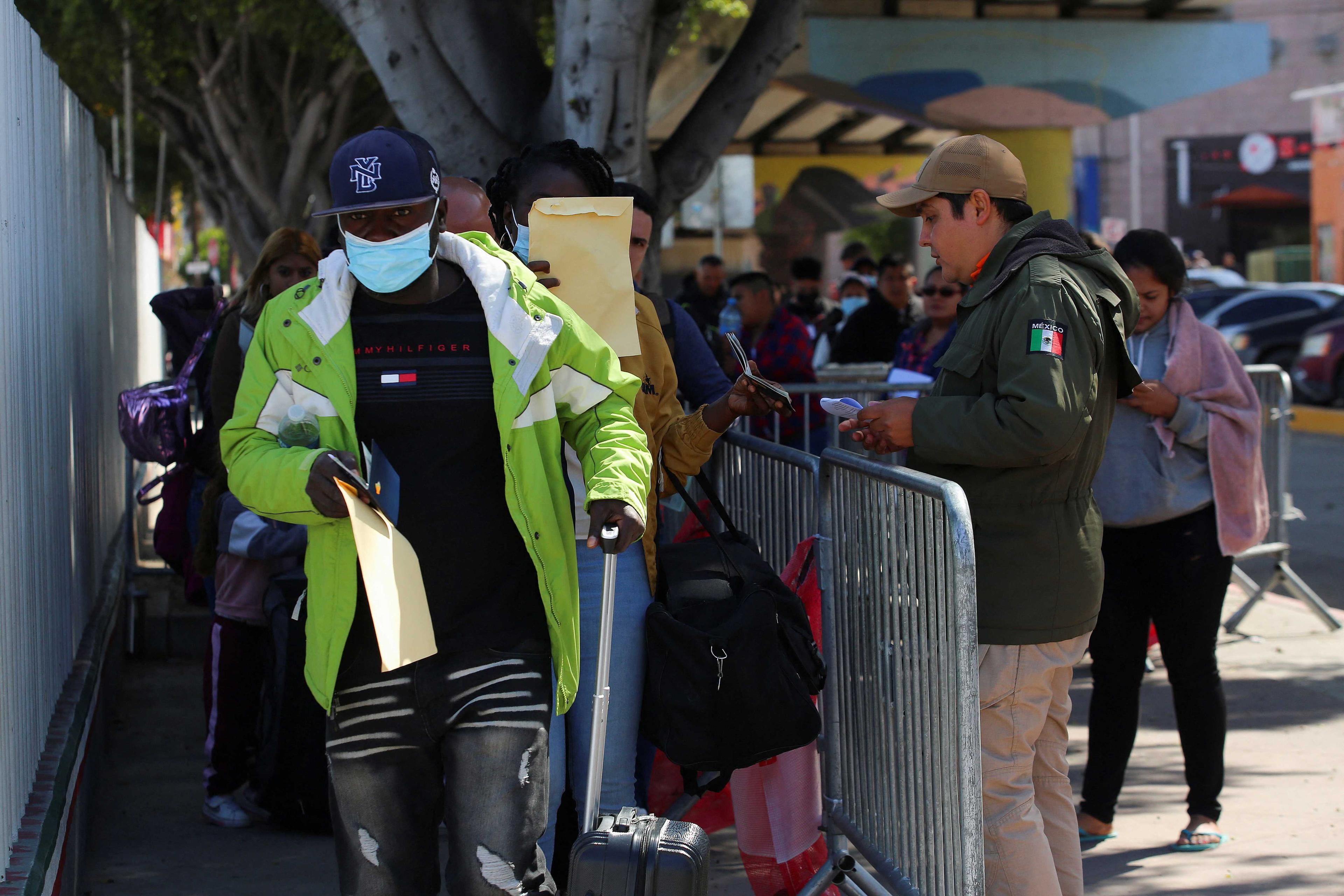 Migrants who requested an appointment for asylum in the US walk towards El Chaparral port of entry, in Tijuana, Mexico May 9. Photo: Reuters