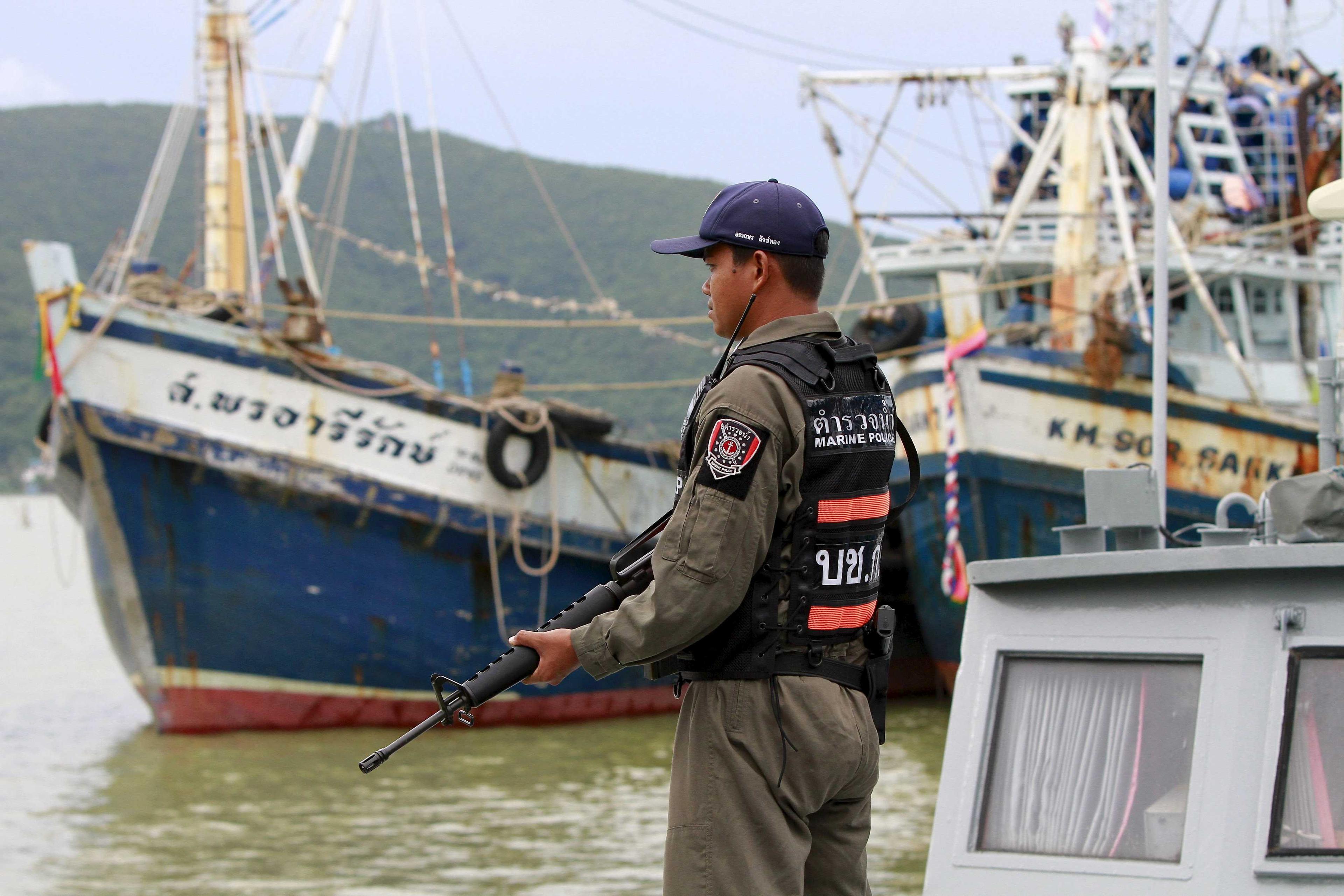 Seorang pegawai polis berdiri di atas bot nelayan semasa pemeriksaan di jeti Songkhla, selatan Thailand 23 Disember 2015. Gambar: Reuters