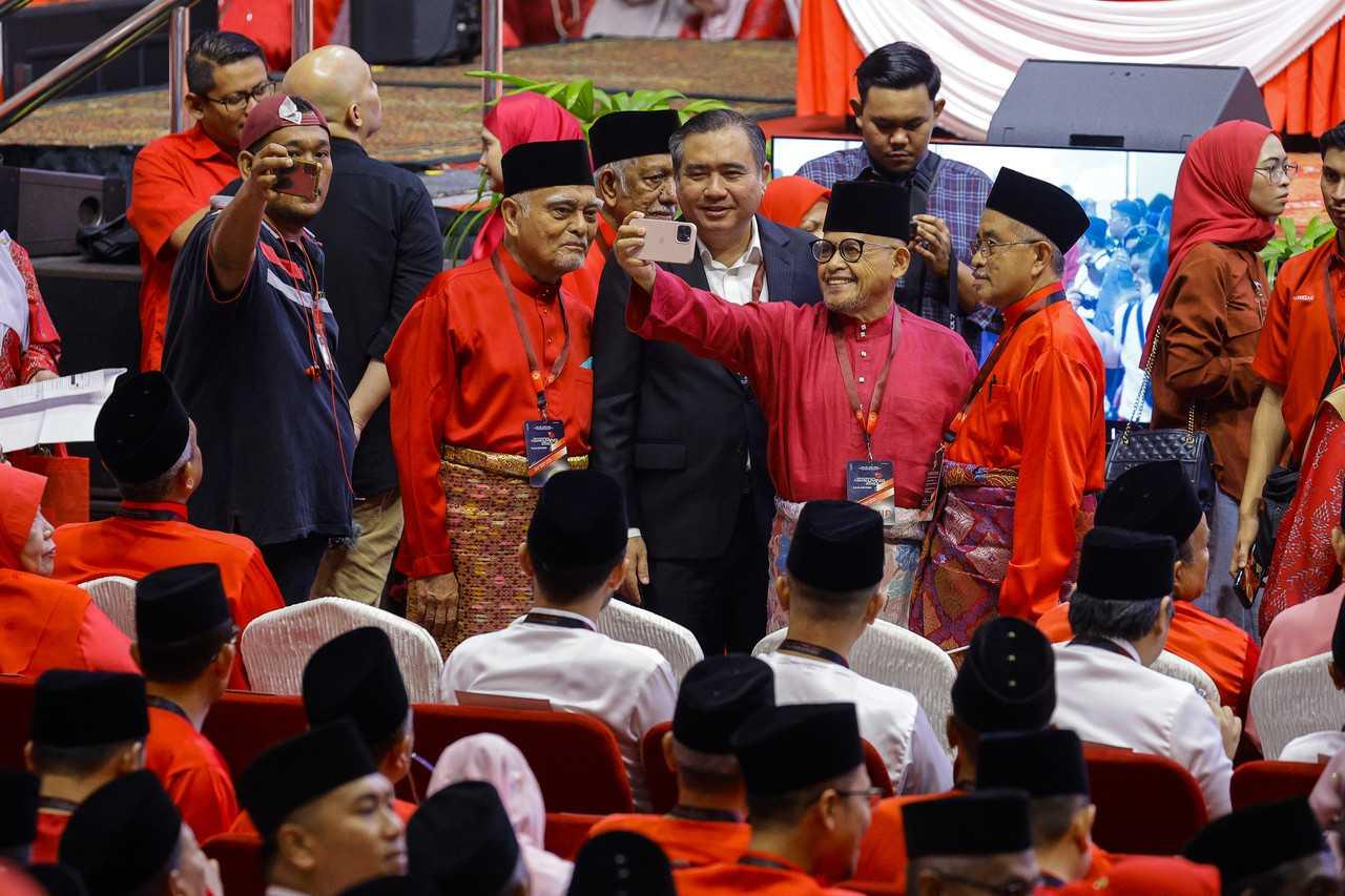 DAP secretary-general Anthony Loke (centre) takes a picture at the Umno general assembly at the World Trade Centre in Kuala Lumpur, June 9. Photo: Bernama
