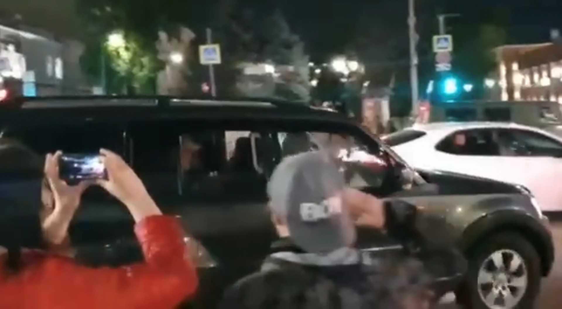 This video grab taken from handout footage posted late on June 24, on the Telegram channel @rstv01 shows Yevgeny Prigozhin leaving in a car the headquarters of the Russian southern military district in the city of Rostov-on-Don as pedestrians film and salute him. Photo: AFP 