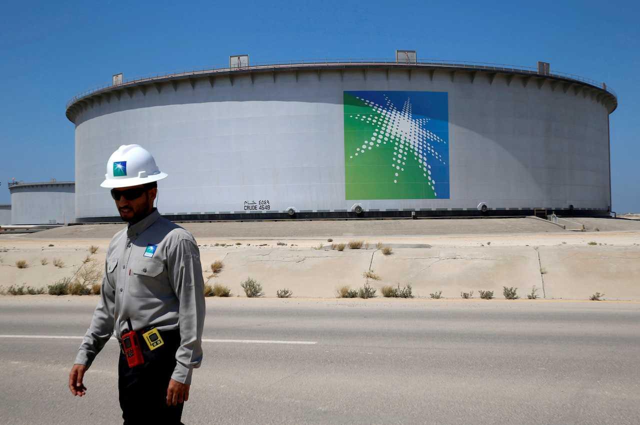 Seorang pekerja Saudi Aramco berjalan berhampiran tangki minyak di kilang penapisan minyak dan terminal minyak Ras Tanura Saudi Aramco di Arab Saudi, 21 Mei 2018. Gambar: Reuters