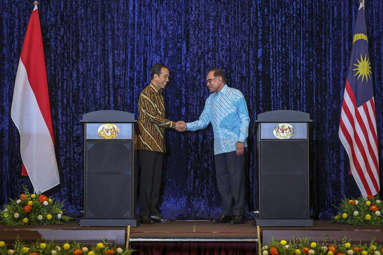 Perdana Menteri Anwar Ibrahim berjabat tangan dengan Presiden Indonesia Joko Widodo semasa lawatan kerja beliau ke Malaysia pada 8 Jun. Gambar: Bernama