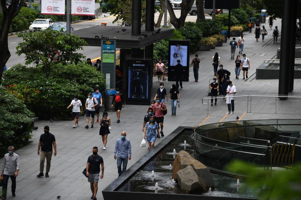People walk along the pavement in the Orchard Road shopping district in Singapore, Sept 25. Photo: AFP