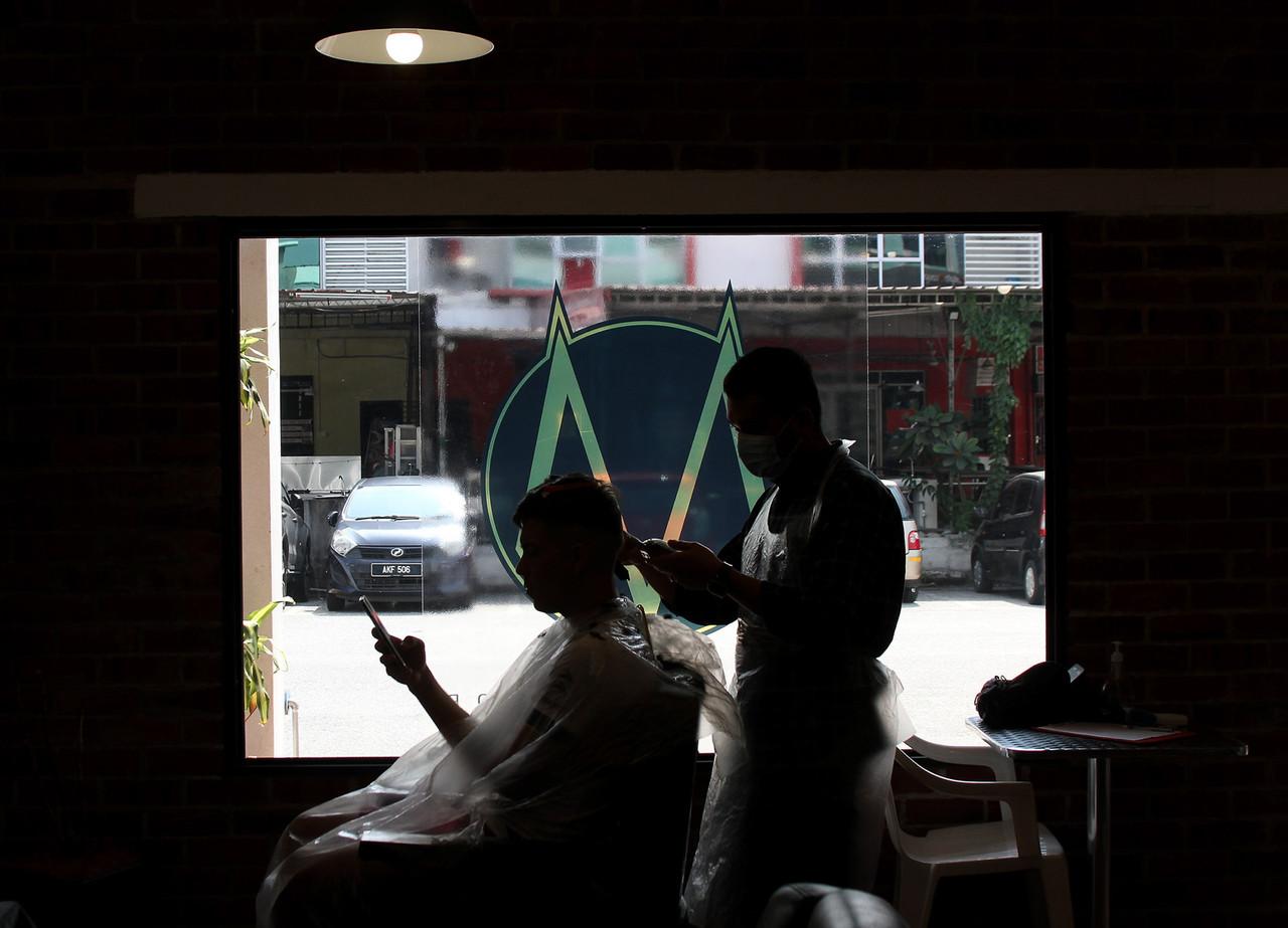 A man in Ipoh, Perak, receives a haircut in Bandar Meru Raya after the state made the transition into Phase Two of the National Recovery Plan today. Photo: Bernama