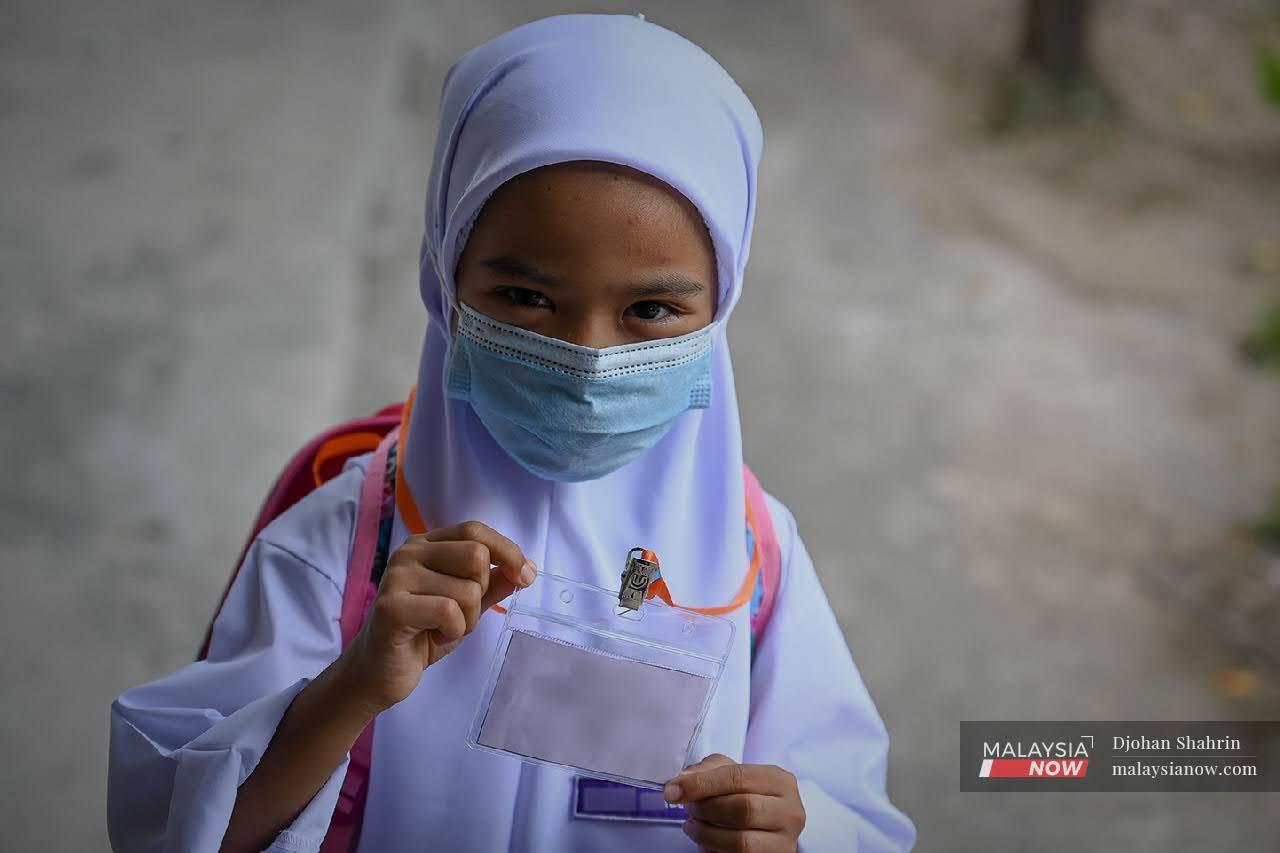 Seorang murid menunjukkan tag namanya di Sekolah Kebangsaan Taman Tasik, Ampang pada 1 Mac lalu.