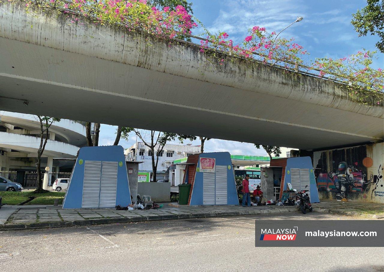 Cobblers sit outside their shops beneath the Satok flyover in Kuching, Sarawak.