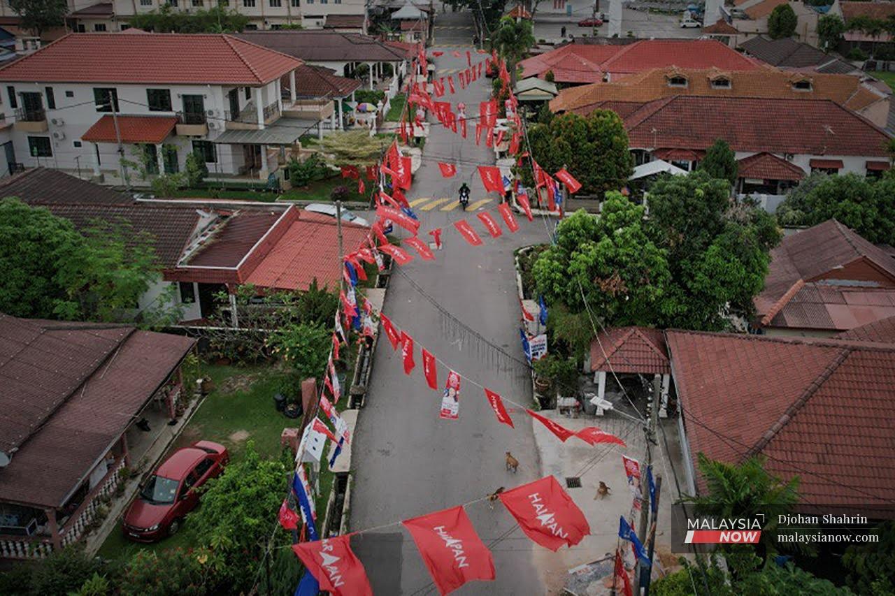 Sebuah motosikal melalui deretan bendera Pakatan Harapan yang digantung di perkampungan Portugis.