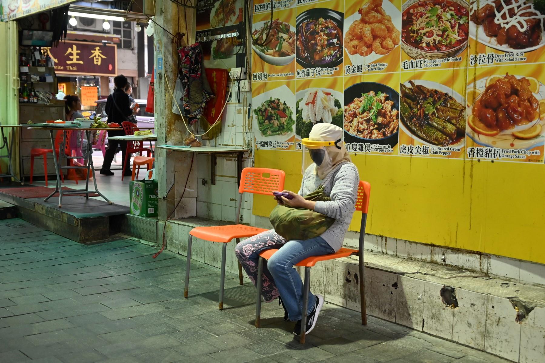 A woman sits outside a restaurant amid pandemic restrictions in Hong Hong on March 2, as the city experiences its worst coronavirus outbreak to date. Photo: AFP