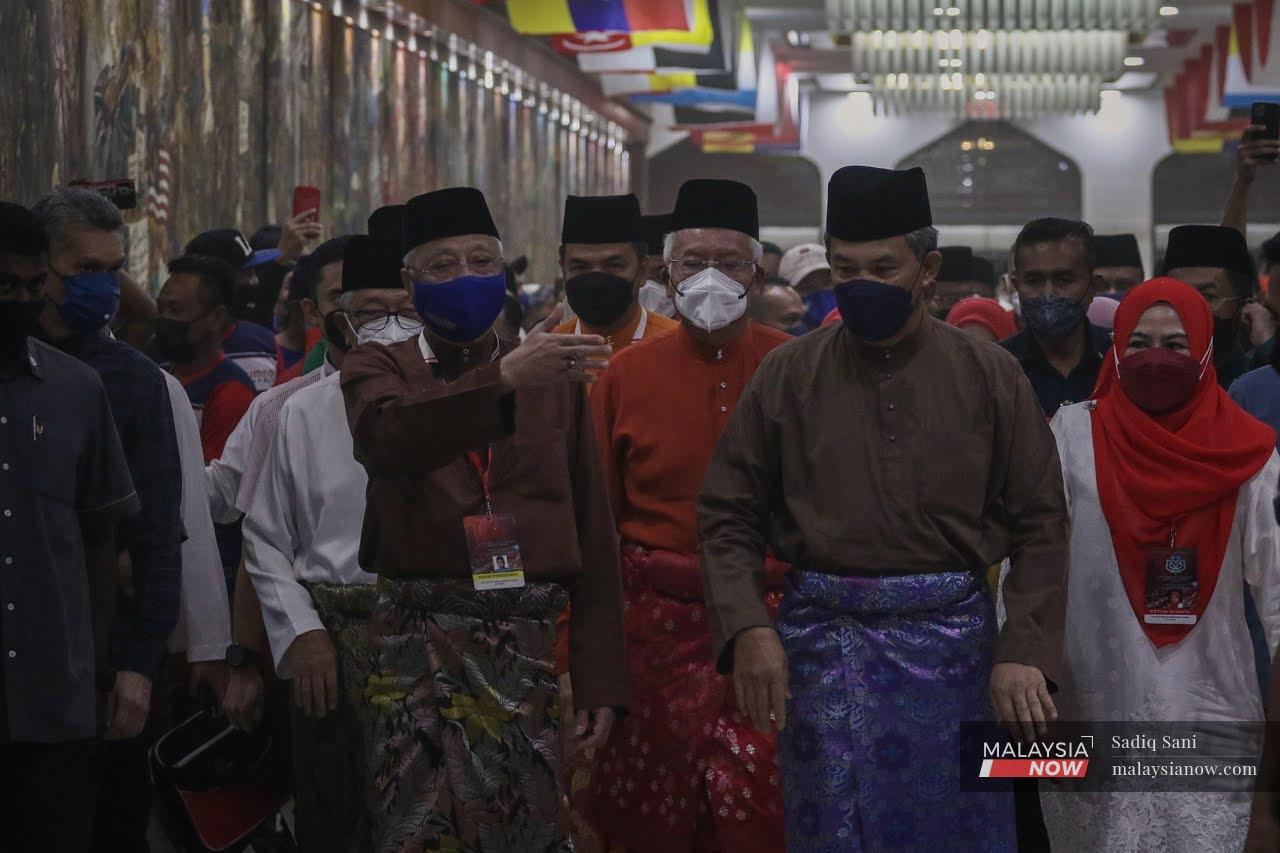 Prime Minister Ismail Sabri Yaakob gestures as he arrives at the World Trade Centre in Kuala Lumpur for the Umno general assembly, flanked by party leaders including deputy president Mohamad Hasan (second right) and Najib Razak (centre).