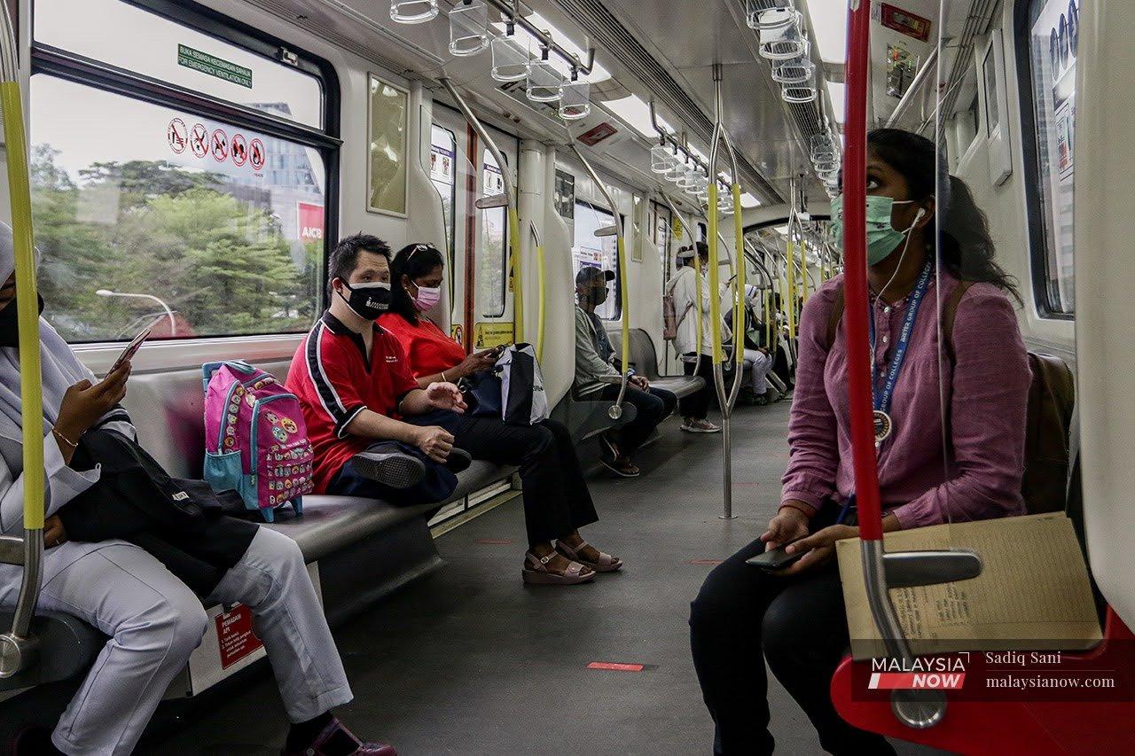 Penumpang LRT menatal telefon pintar sebelum turun ke destinasi masing-masing.