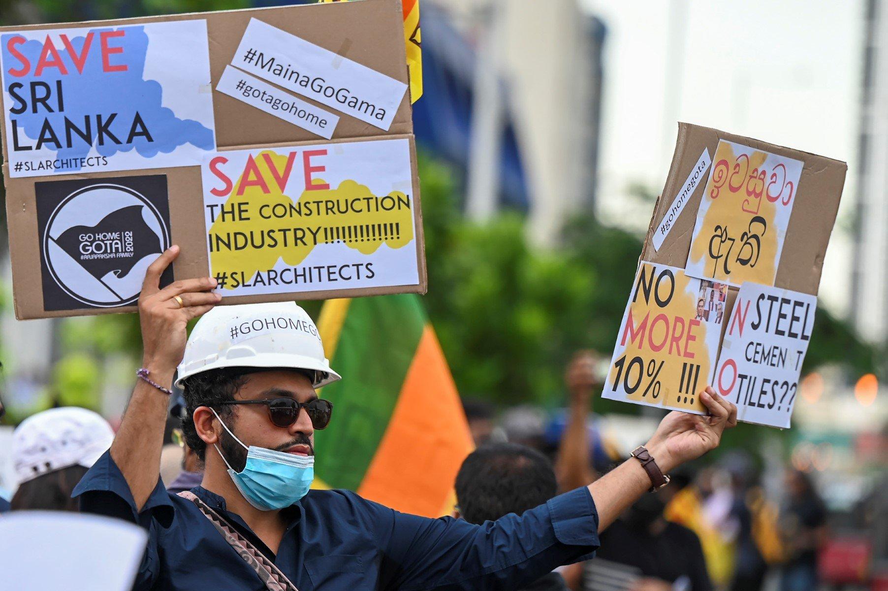A protester holds placards during an anti-government demonstration outside the Sri Lanka prime minister's official residence in Colombo on April 26. Photo: AFP