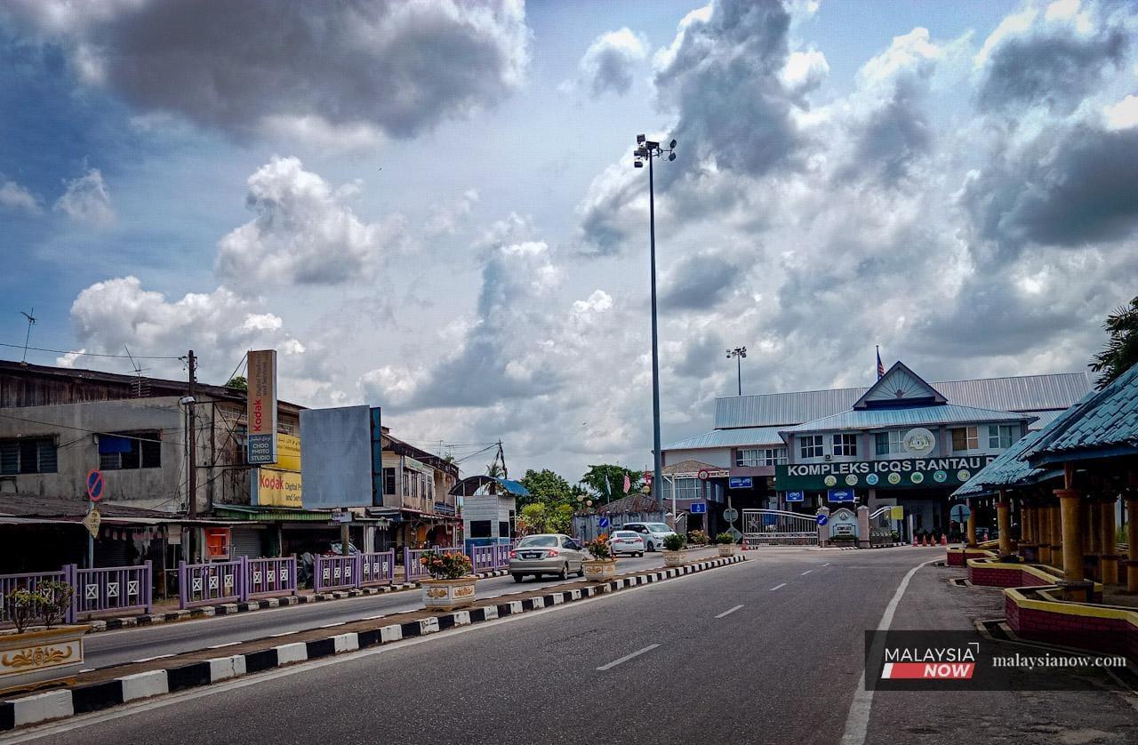 A handful of cars make their way through Rantau Panjang town, near the immigration checkpoint.