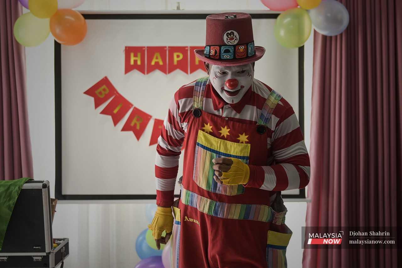 Mohd Fadly Abu Hasan, berkostum lengkap dengan solekan sebagai Awang the Clown atau Awang Badut, menghiburkan kanak-kanak di sebuah majlis hari jadi.