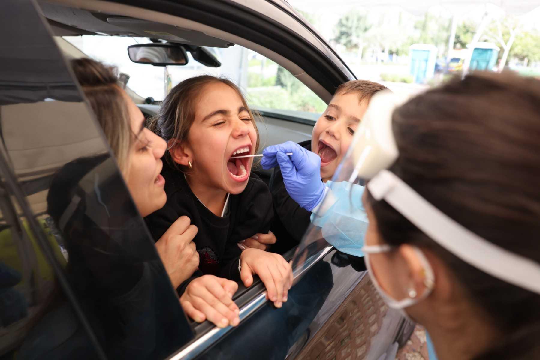 An Israeli paramedic collects a swab sample from a child at the Magen David Adom (Red Shield of David) Covid-19 testing centre in Jerusalem on Jan 11. Photo: AFP