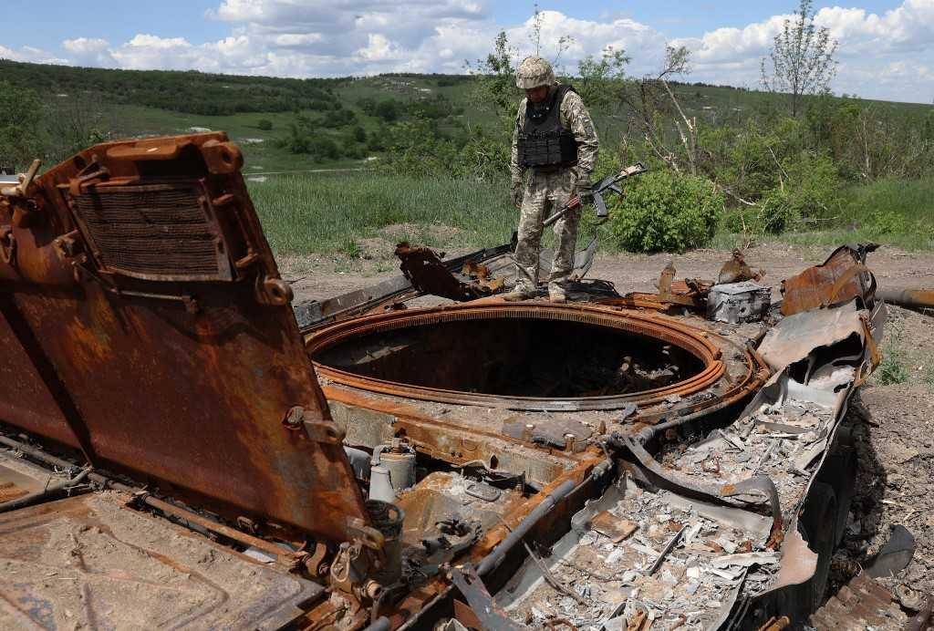 A Ukrainian serviceman inspects a destroyed Russian tank at an abandonned Russian position near the village of Bilogorivka not far from Lysychansk, Lugansk region, on June 17. Photo: AFP