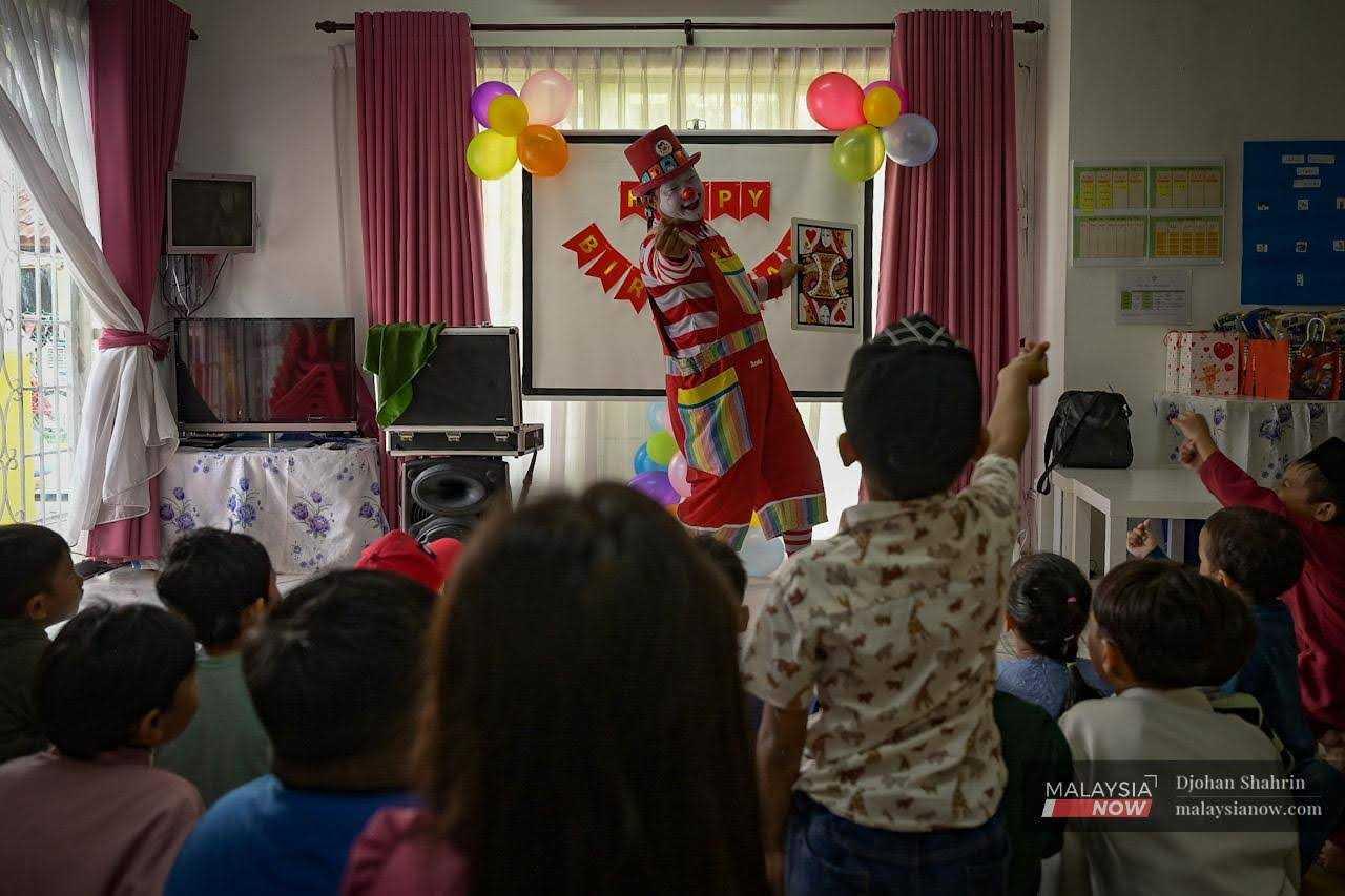 The children love him, and enthusiastically join in his performance.