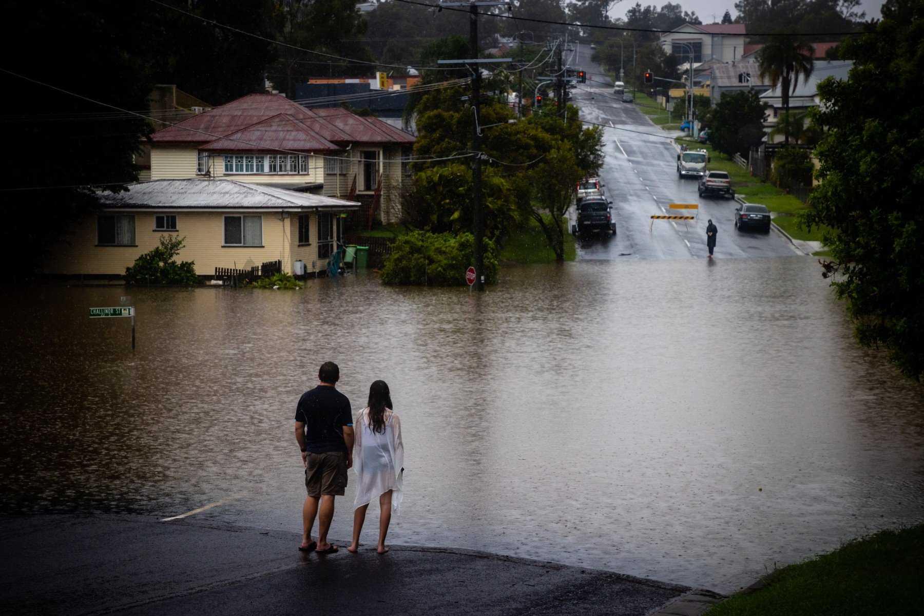 Residents look at rising floodwaters of the Bremer river in West Ipswich, Australia's Queensland state on Feb 26. Photo: AFP
