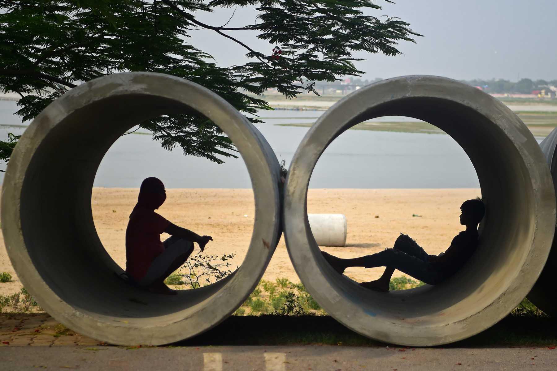 People rest inside cement pipes lying along the roadside on a hot summer day in Allahabad on May 31. Photo: AFP