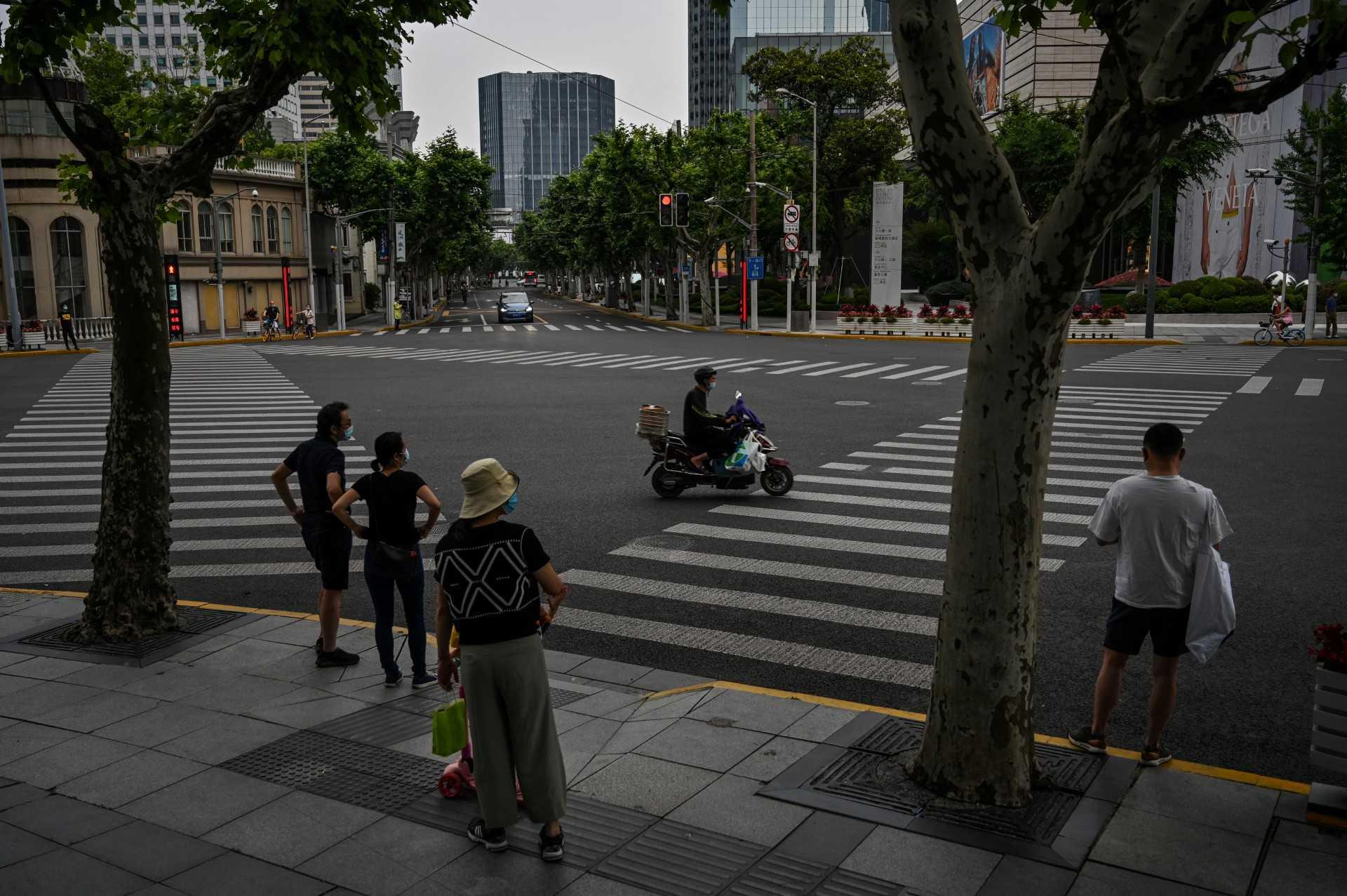 People wait to cross a street during a Covid-19 lockdown in the Jing'an district of Shanghai on May 30. Photo: AFP