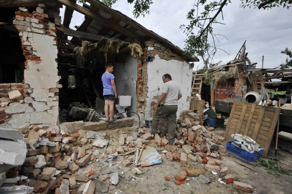 People clear debris of a house, destroyed during Russia's invasion of Ukraine in the village of Pidgayne, Kyiv region, on July 9. Photo: AFP