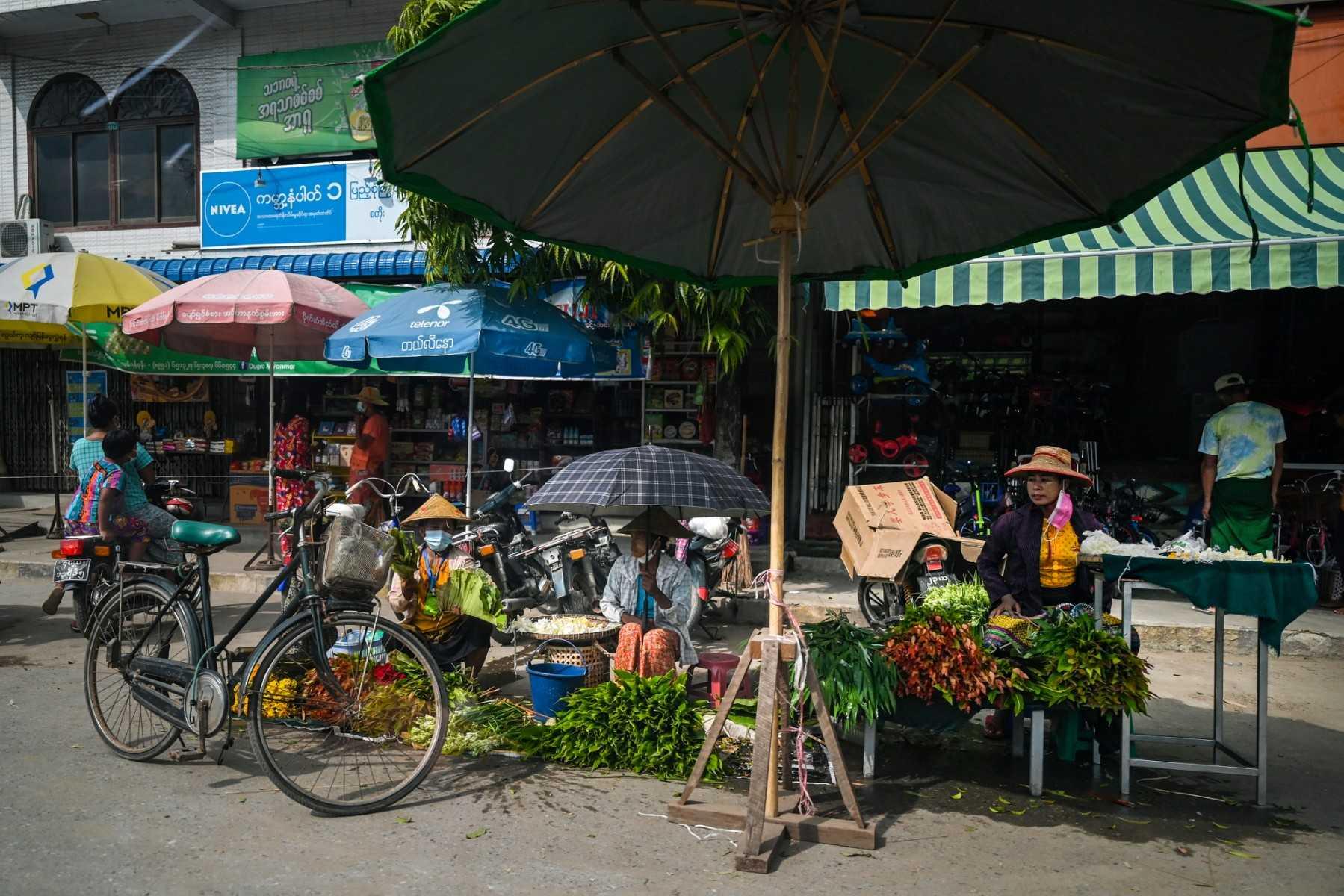 This photo taken on Oct 10, 2021 shows street vendors selling vegetables on a street in Shwebo township in Sagaing region. Photo: AFP