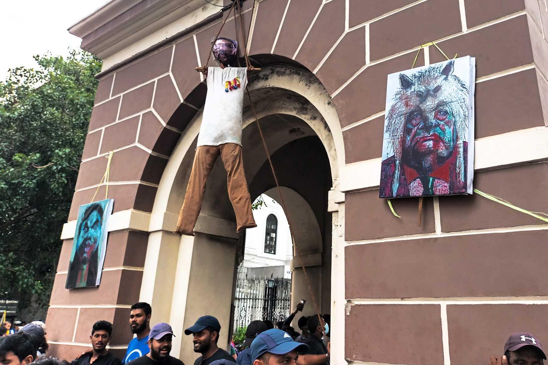 Activists stand under an effigy of Sri Lanka's President Gotabaya Rajapaksa, hanging from a clock tower near his official residence, in Colombo on July 10. Photo: AFP 
