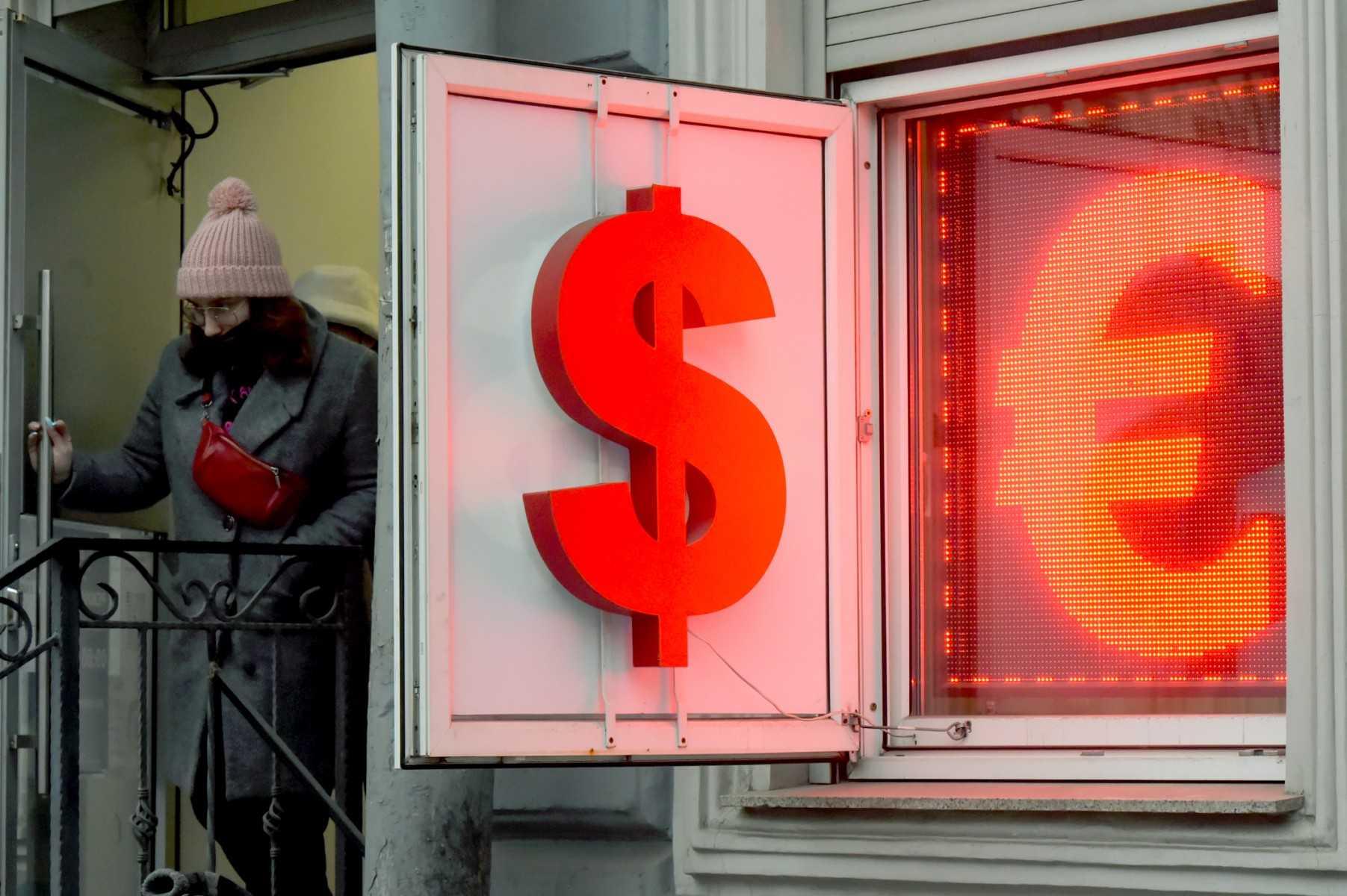 A woman leaves a currency exchange office displaying the US dollar and the euro signs in Saint Petersburg on March 2. Photo: AFP