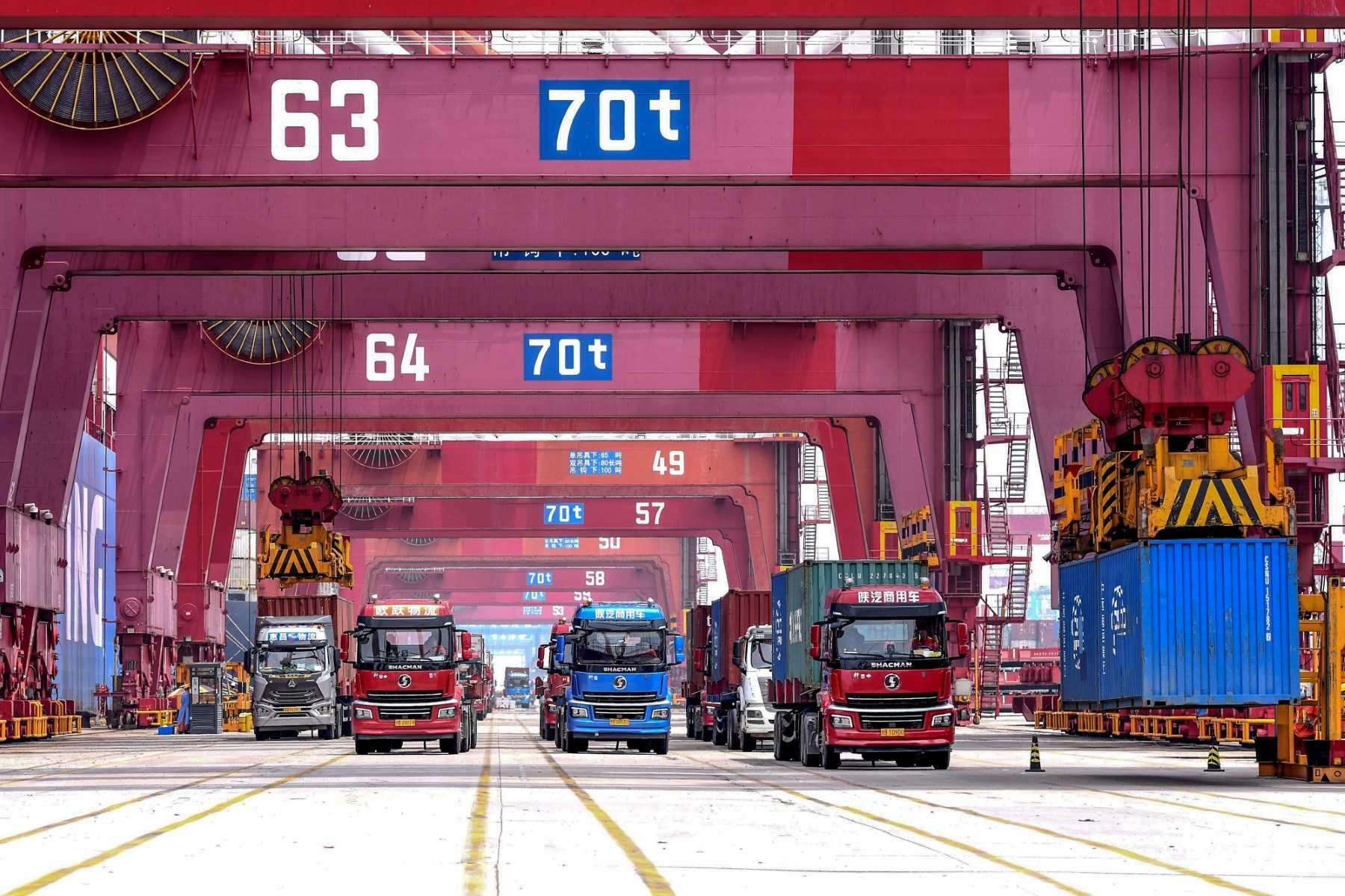 Cranes load containers onto trucks at a port in Qingdao, in China's eastern Shandong province on July 13. Photo: AFP
