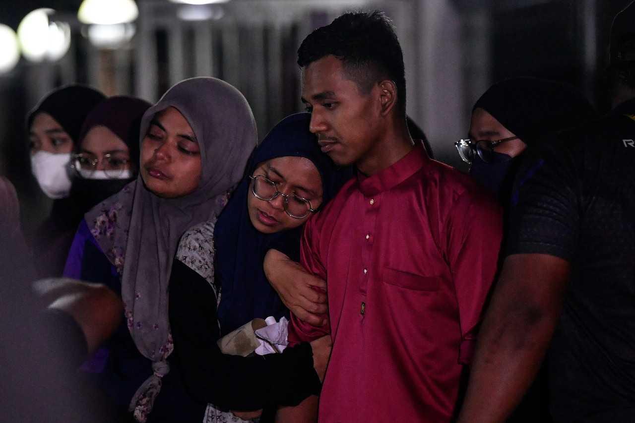 Family members grieve at the funeral in Permatang Pauh of four relatives who died in an accident on the North-South Expressway on July 13. Photo: Bernama 