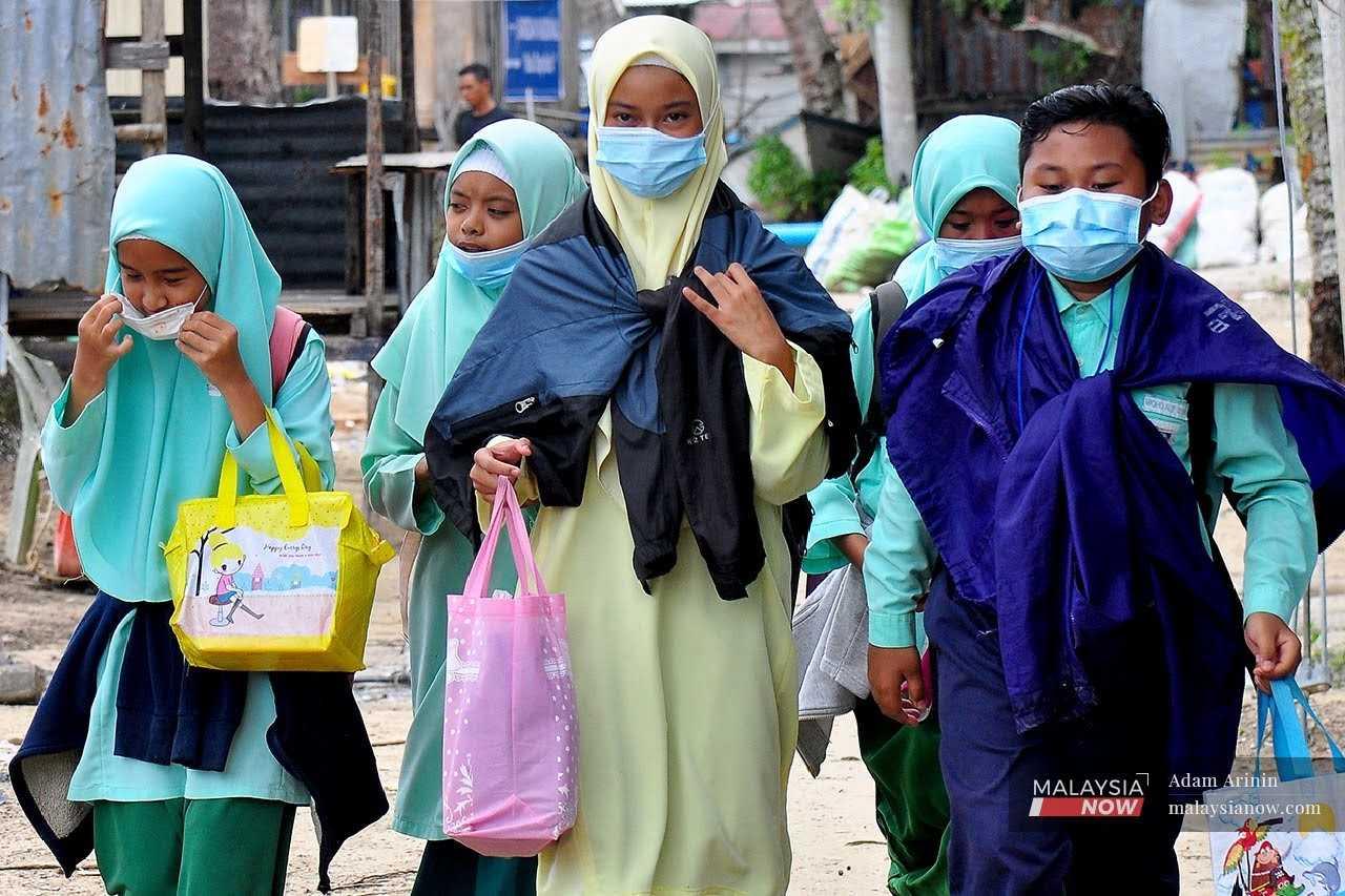Kanak-kanak berjalan kaki ke sekolah di Pulau Gaya, Sabah.