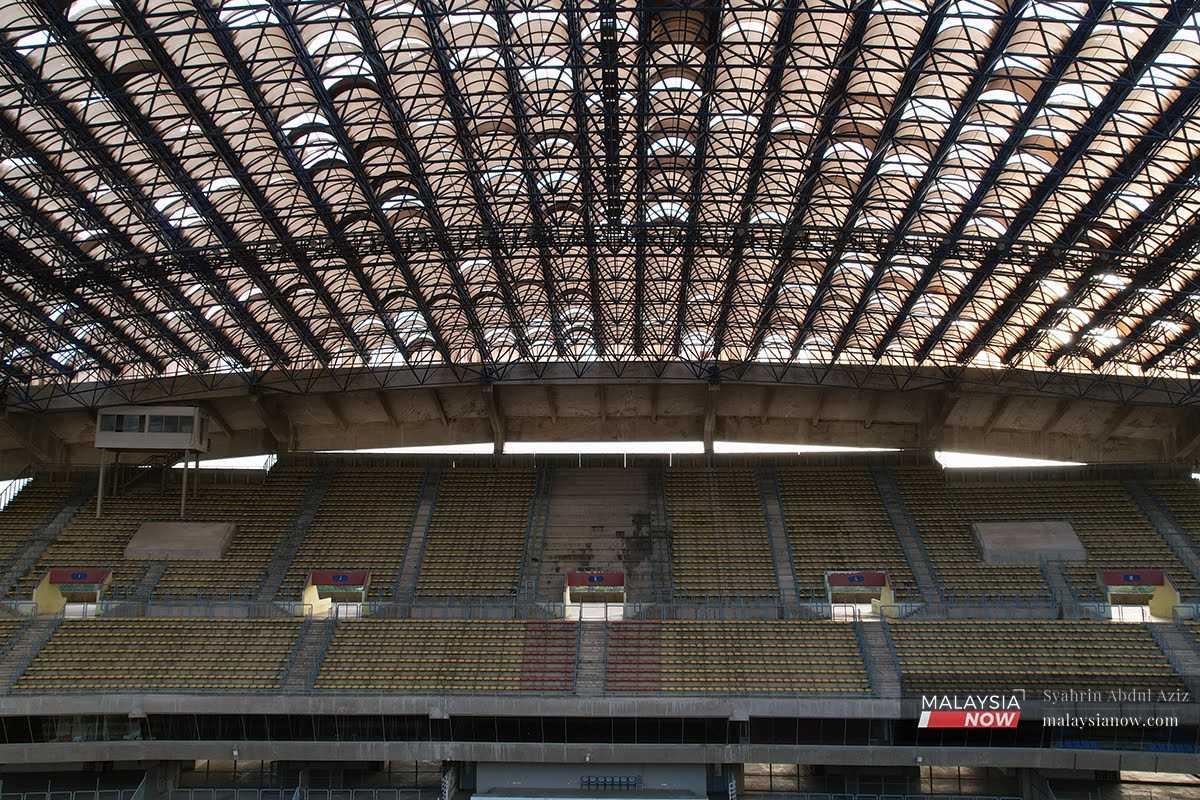 Sunlight pours through the cracks and gaps left by broken panels in the roof of the once mighty Shah Alam stadium.