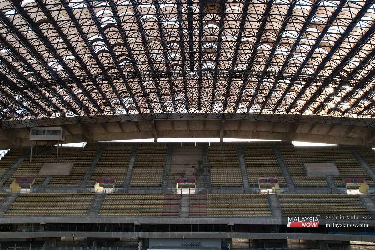 Sunlight pours through the cracks and gaps left by broken panels in the roof of the once mighty Shah Alam stadium. 
