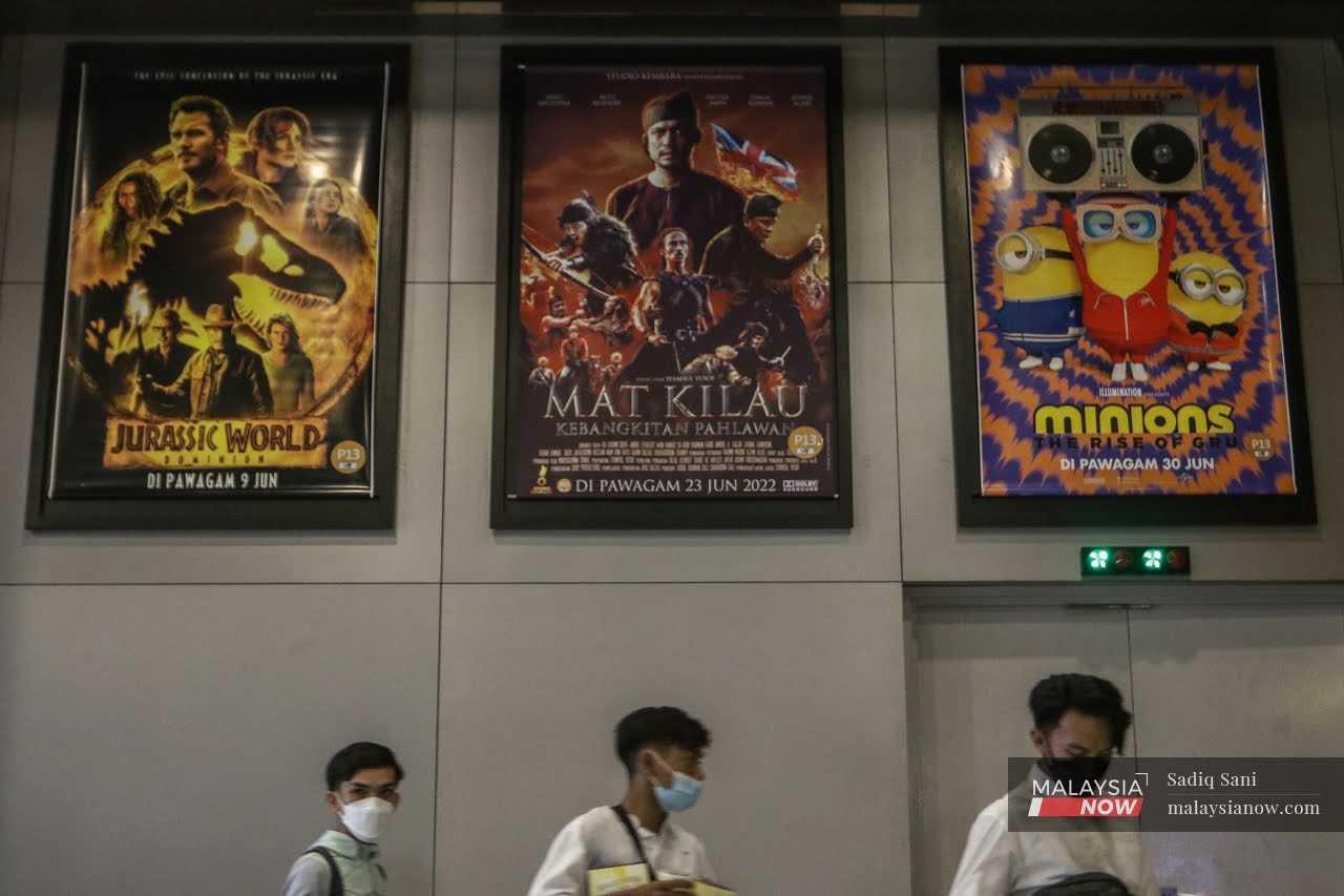 Penonton melintasi poster filem Mat Kilau: Kebangkitan Pahlawan di pawagam Putrajaya.