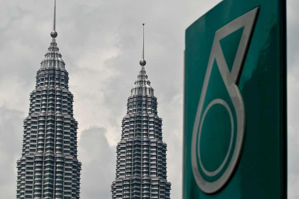 The iconic Twin Towers are seen in the background of a Petronas logo at a petrol station in Kuala Lumpur on Aug 13, 2014. Photo: AFP