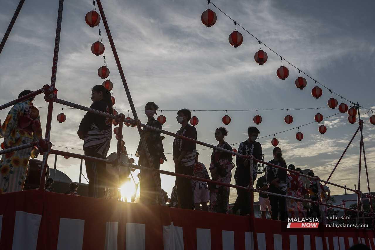 As the sun sets, dancers prepare for the first performance on a raised stage known as a yagura. 