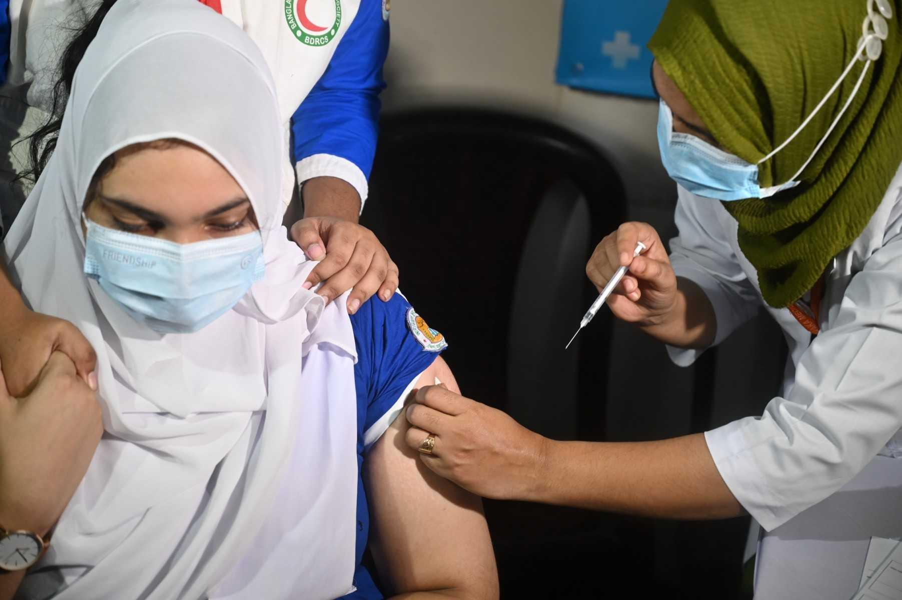 Seorang petugas kesihatan Bangladesh memberikan suntikan vaksin kepada pelajar perubatan di Dhaka. Gambar: AFP