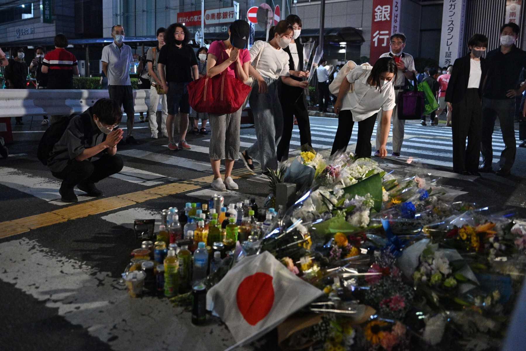 People pay their respects in front of a makeshift memorial outside Yamato-Saidaiji Station, where former Japanese prime minister Shinzo Abe was shot earlier in the day, in Nara on July 8. Photo: AFP