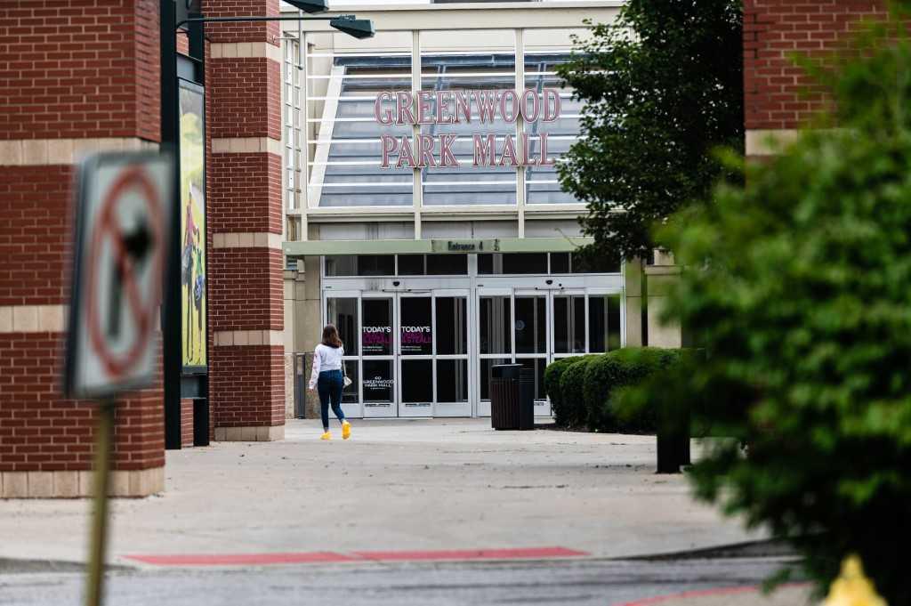 Seorang wanita berjalan di pintu masuk medan selera Greenwood Park Mall di mana kejadian tembakan rambang meragut tiga nyawa berlaku pada 18 Julai. Gambar: AFP