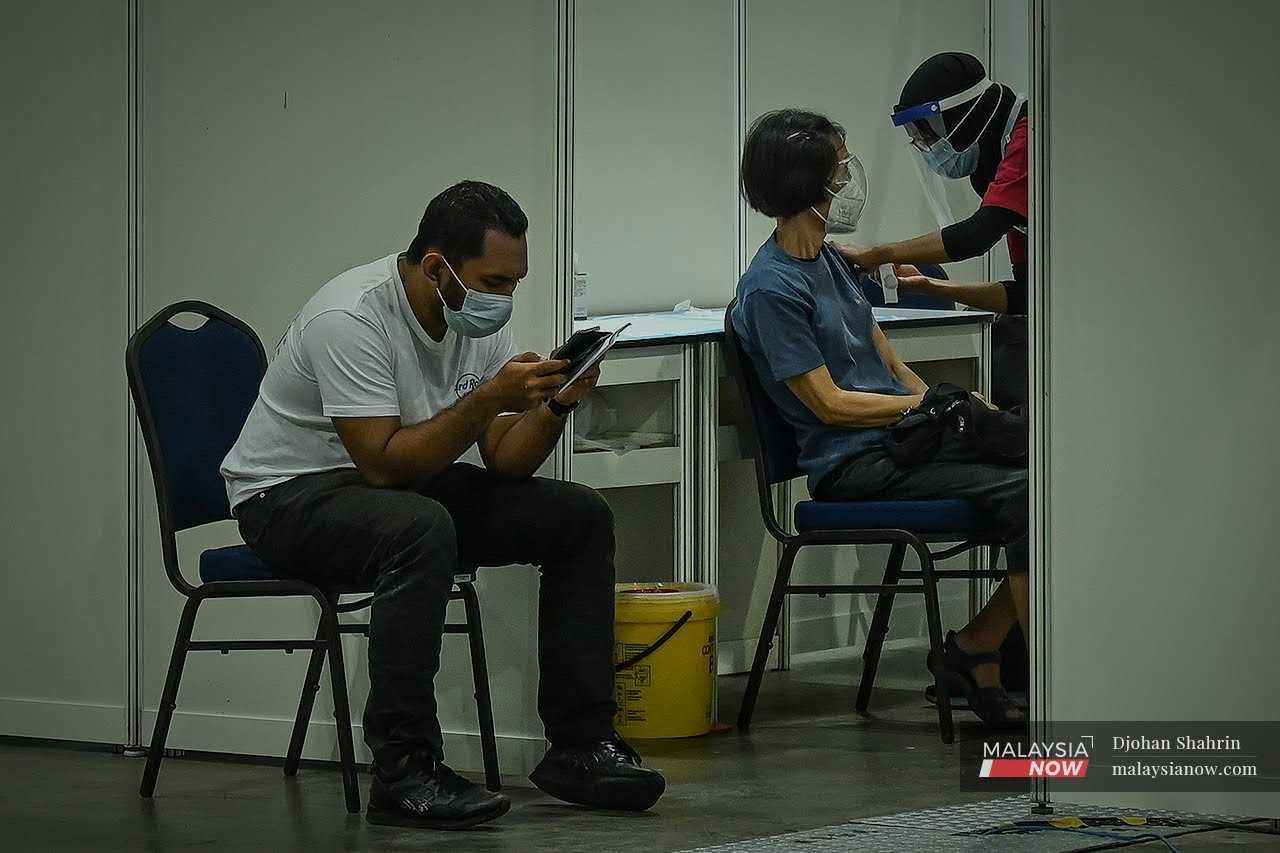 A health worker administers a dose of Covid-19 vaccine to a senior citizen at the Mitec vaccination centre in Kuala Lumpur in this file picture.