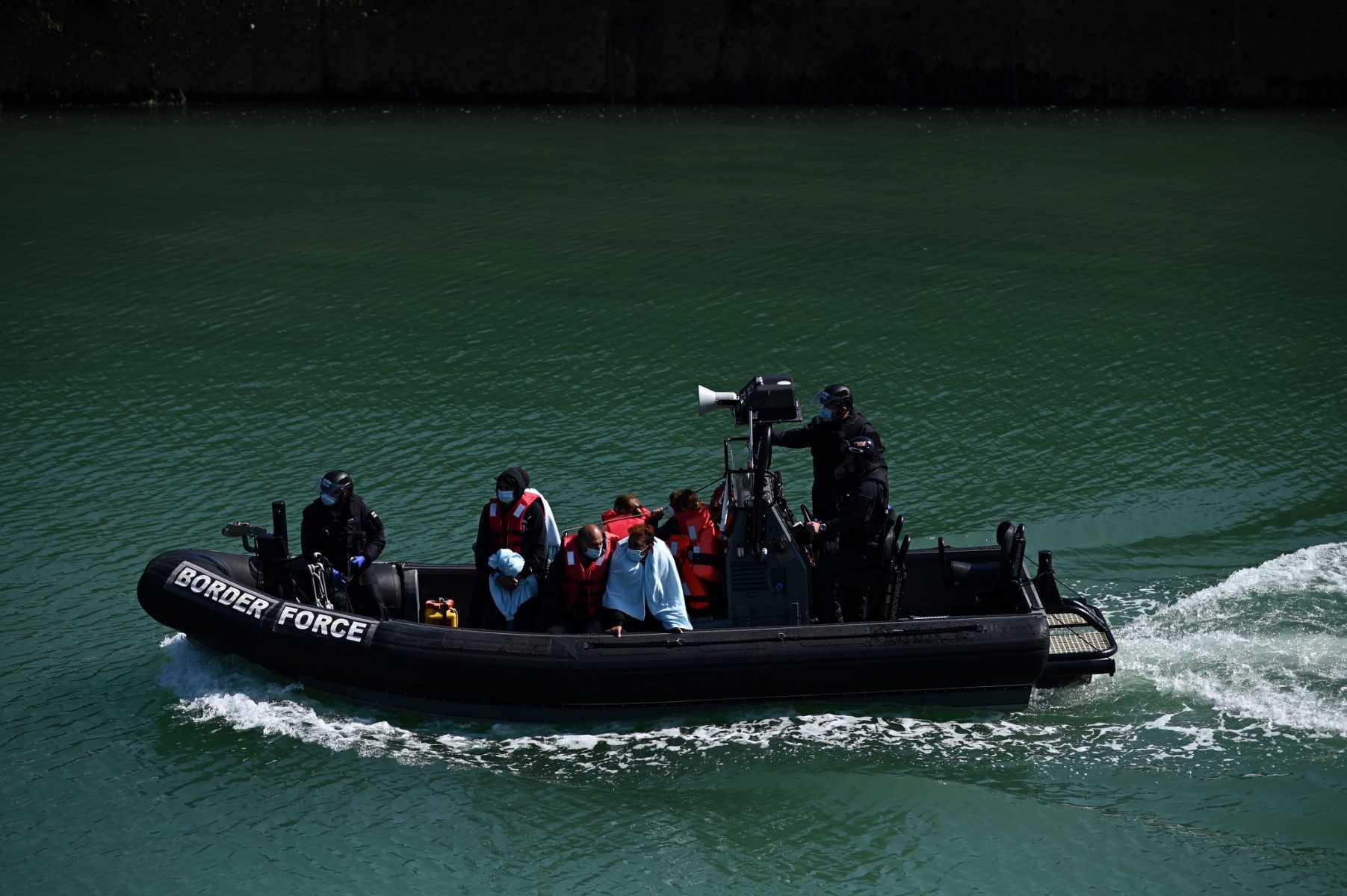 Migrants are seen on the UK Border Force rubber dinghy, after they were picked up at sea while attempting to cross the English Channel, and brought to the Marina in Dover, southeast England, on June 16. Photo: AFP