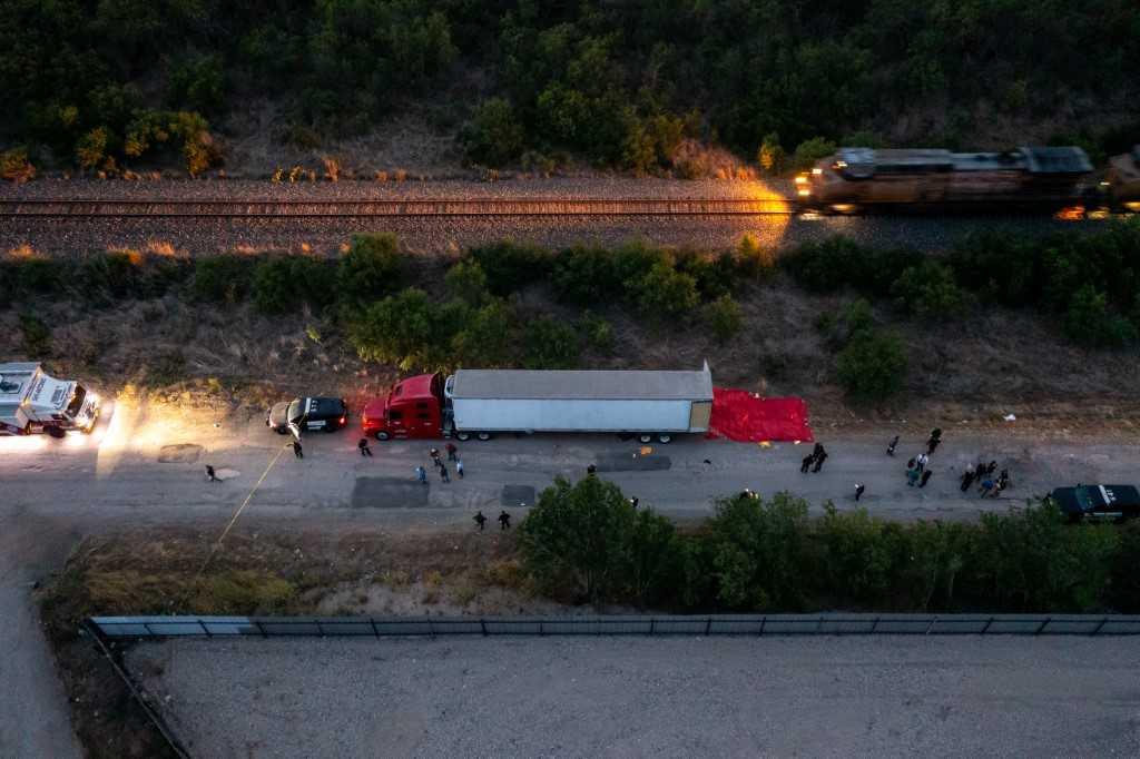 In this aerial view, members of law enforcement investigate a tractor trailer on June 27, in San Antonio, Texas.  Photo: AFP
