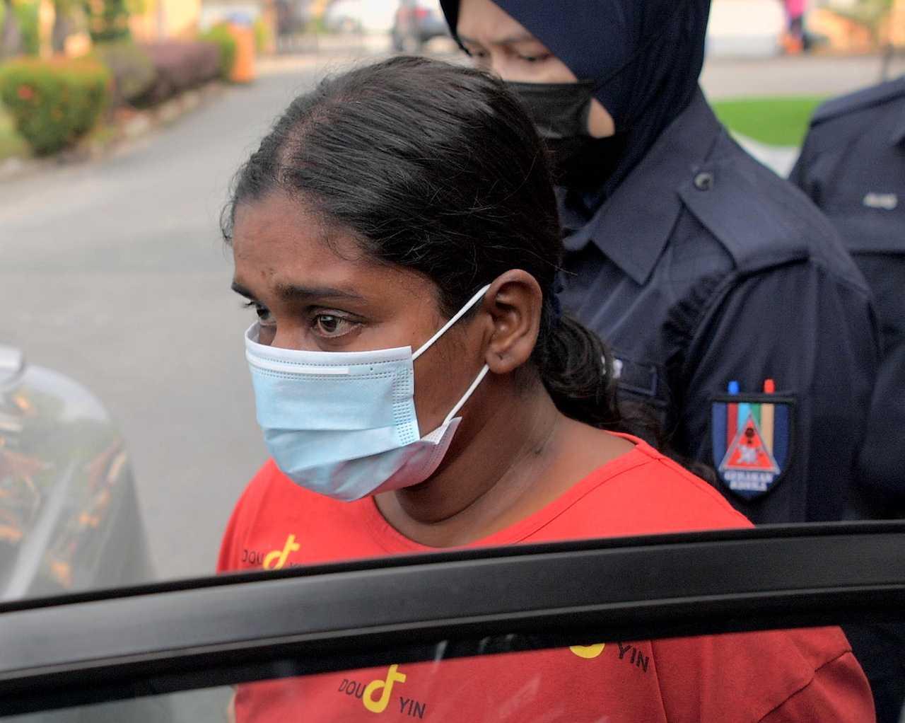 Sembakavali is escorted from the Magistrate's Court in Batu Pahat today. Photo: Bernama