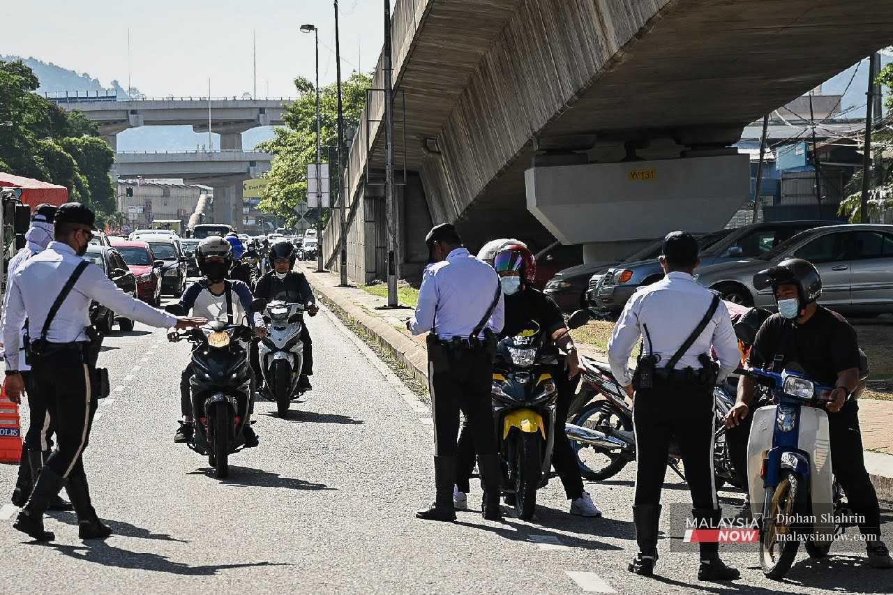Anggota polis trafik dalam operasi Ops Bersepadu memeriksa penunggang motorsikal di ibu negara.