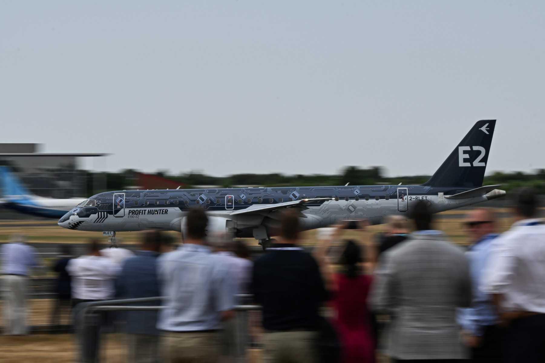 Visitors look at the Embraer E2 Profit Hunter plane taking off during the airshow of the Farnborough Airshow, in Farnborough, on July 18. Photo: AFP