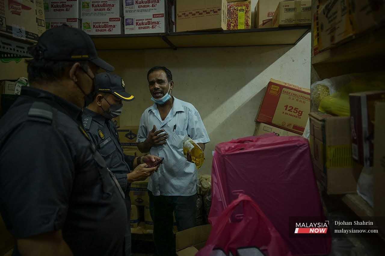 Seorang penguat kuasa KPDHEP memeriksa minyak masak polibeg di Pasar Chow Kit, Kuala Lumpur.