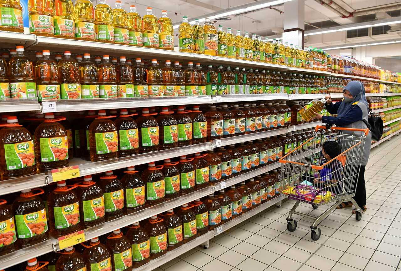 A woman shops for cooking oil at a supermarket. Photo: Bernama